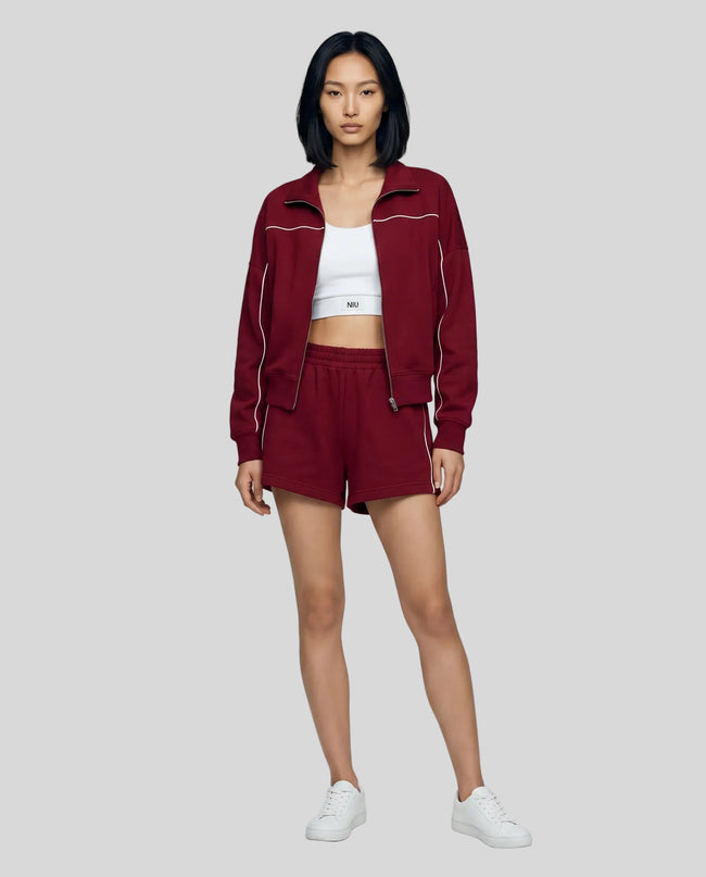 Model wearing Athlesi burgundy TrackEase jacket and shorts set full body front