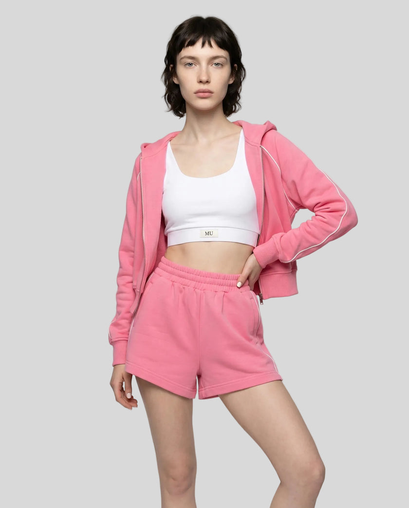 Side view of model wearing Athlesi hot pink TrackEase jacket and shorts set