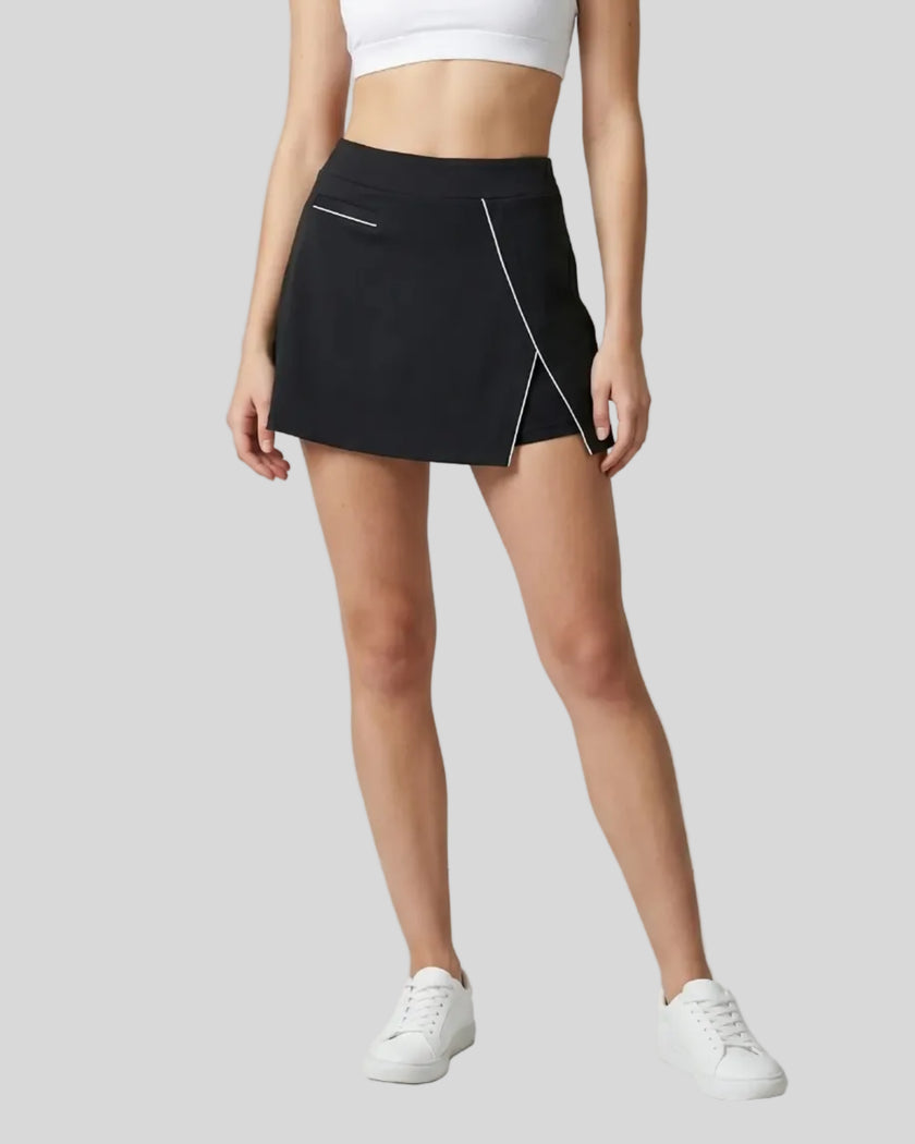 Lower body front view of a woman wearing the Athlesi TrackLine A-Line Skirt in black