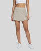Lower body front view of a woman wearing the Athlesi TrackLine A-Line Skirt in light coffee