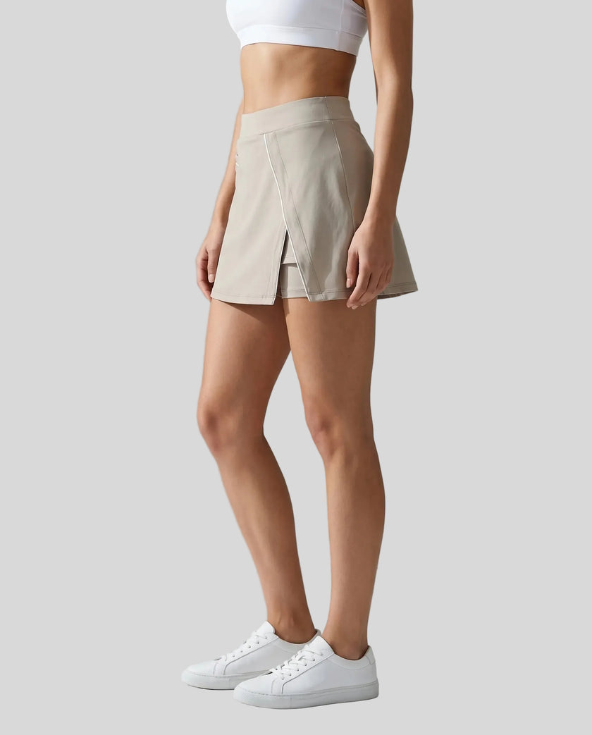 Side view of a woman wearing the Athlesi TrackLine A-Line Skirt in light coffee