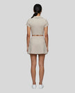 Full body back view of the Athlesi TrackLine A-Line Skirt in light coffee styled with the matching TrackLine Lapel Crop Top