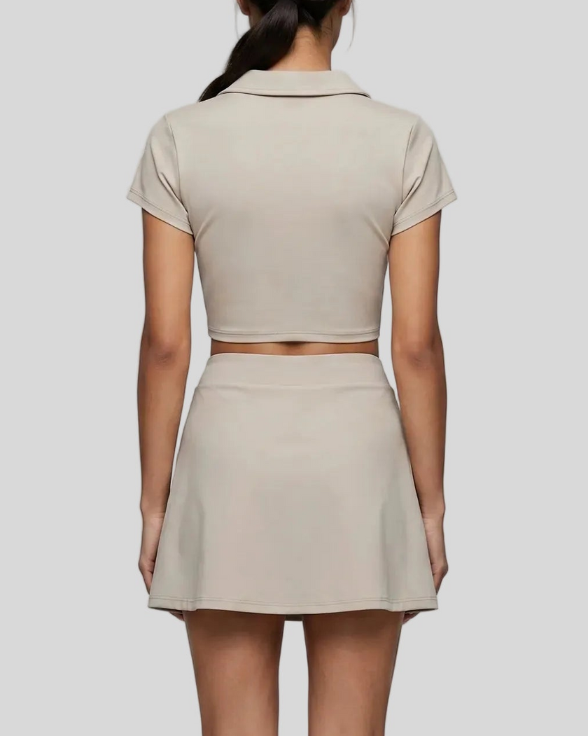 Mid body back view of the Athlesi TrackLine A-Line Skirt in light coffee styled with the matching TrackLine Lapel Crop Top