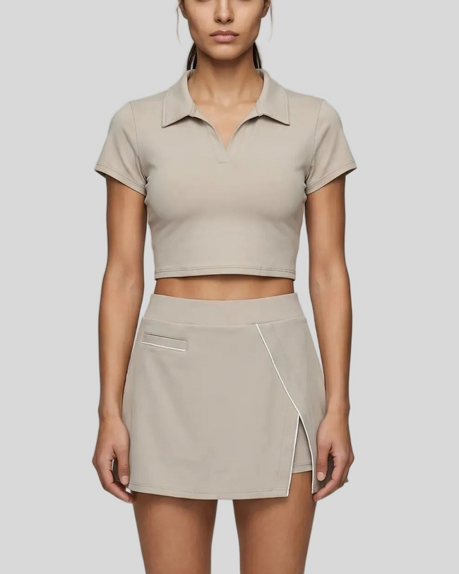 Mid body front view of the Athlesi TrackLine A-Line Skirt in light coffee styled with the matching TrackLine Lapel Crop Top