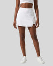 Lower body front view of a woman wearing the Athlesi TrackLine A-Line Skirt in white