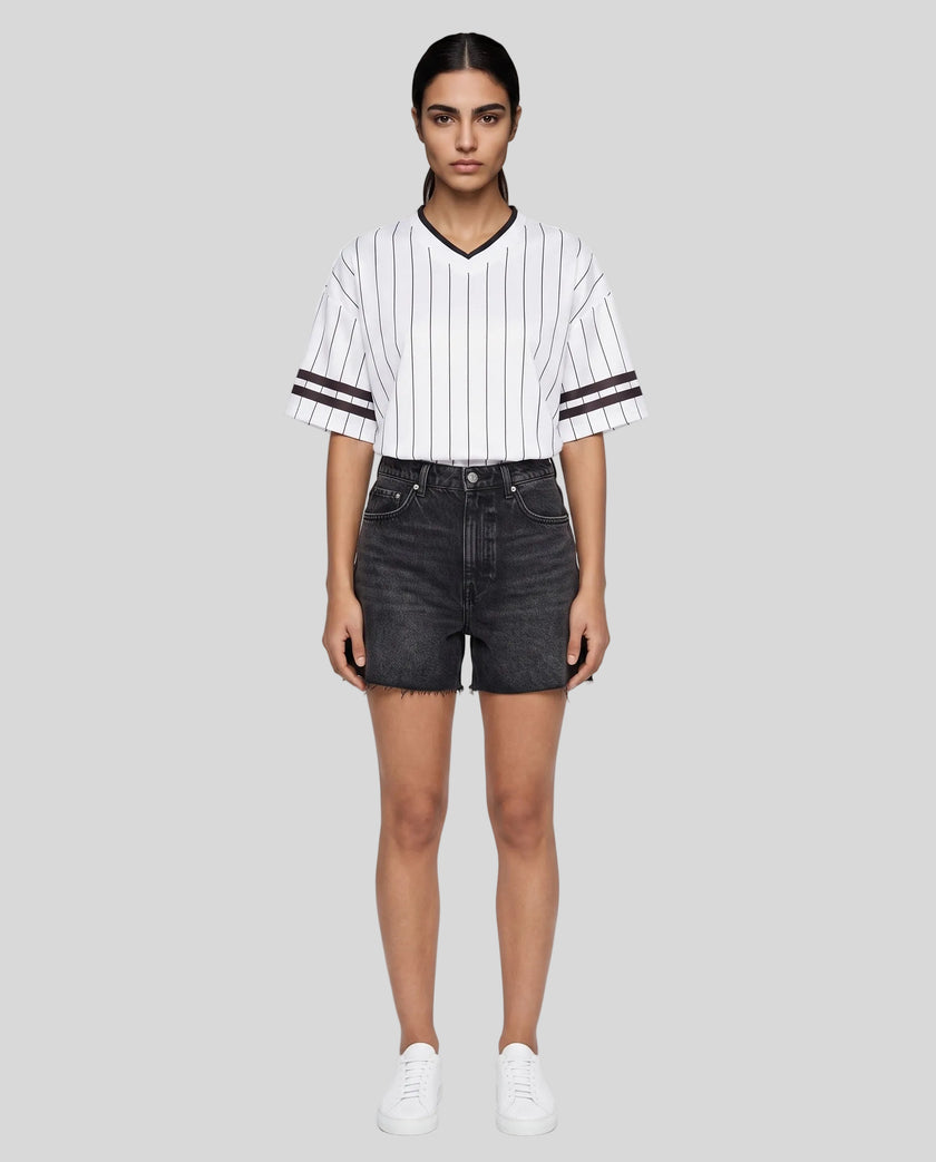 Woman wearing the TrackLine Baseball Striped Tee in White from a front angle showing the oversized silhouette and striped sleeve details.