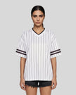 Woman wearing the TrackLine Baseball Striped Tee in White from the front showing its relaxed unisex fit and retro athletic styling.