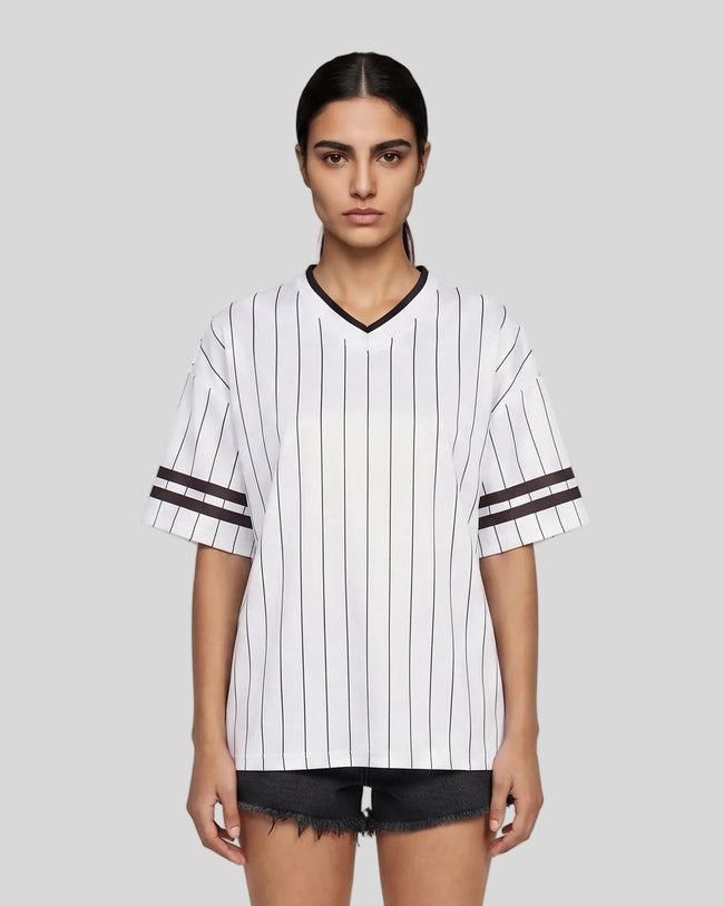 Woman wearing the TrackLine Baseball Striped Tee in White from the front showing its relaxed unisex fit and retro athletic styling.