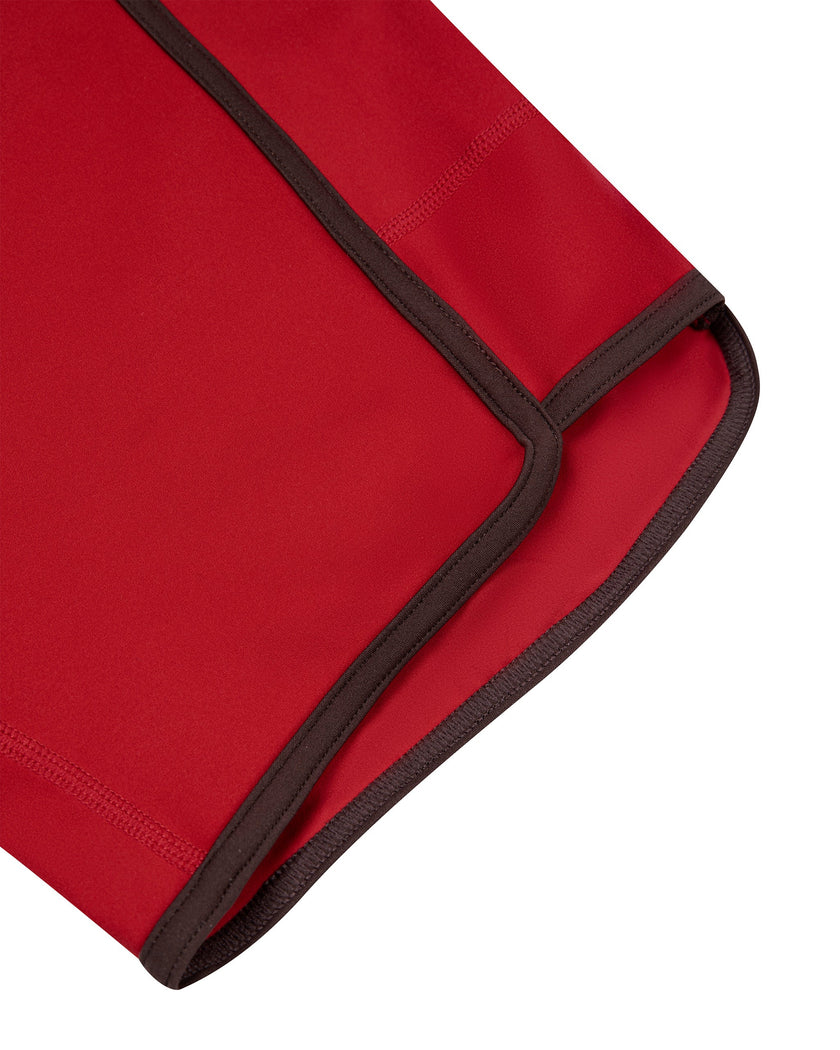 Closeup of the curved leg opening and contrast binding on the TrackLine Color Block Performance Shorts in Red