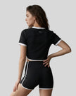 Model wearing the TrackLine Color Block Performance Tee in Black, back view