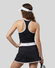 Woman wearing Athlesi TrackLine Color Block Skort in Black mid-body back view showing contrast waistband and skirt silhouette