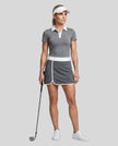 Woman wearing Athlesi TrackLine Color Block Skort in Dark Gray full-body front view