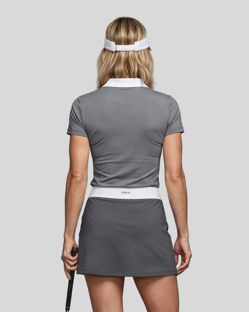 Woman wearing Athlesi TrackLine Color Block Skort in Dark Gray mid-body back view showing contrast waistband and skirt silhouette