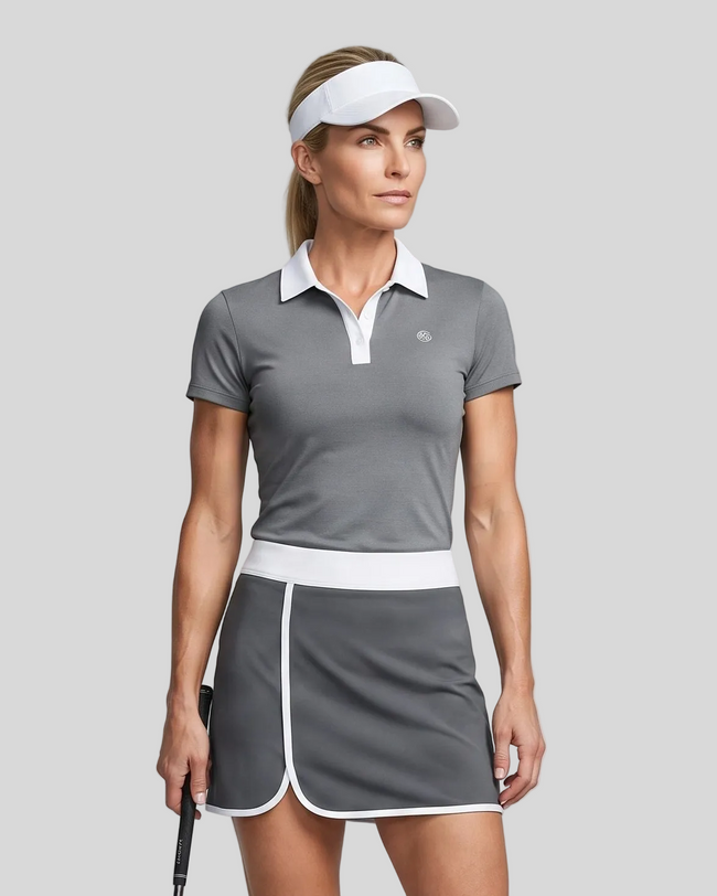 Woman wearing Athlesi TrackLine Color Block Skort in Dark Gray mid-body front view showing contrast waistband and overlapping hem