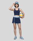 Woman wearing Athlesi TrackLine Color Block Skort in Navy Blue full-body front view