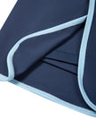 Athlesi TrackLine Color Block Skort in Navy Blue closeup of overlapping front hem with light blue contrast trim