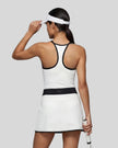 Woman wearing Athlesi TrackLine Color Block Skort in White mid-body back view showing contrast waistband and skirt silhouette