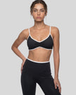 Model wearing the Athlesi TrackLine Color Block Sports Bra in black and white front view