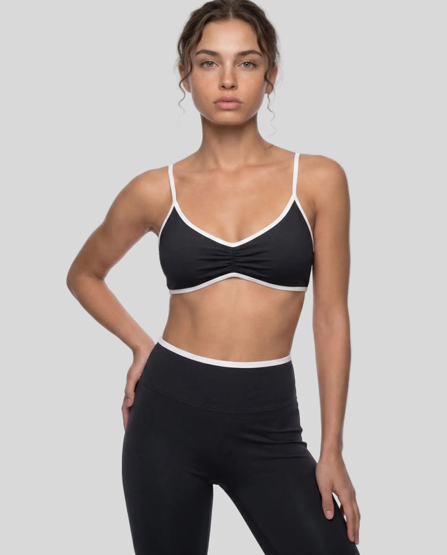 Model wearing the Athlesi TrackLine Color Block Sports Bra in black and white front view