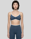 Model wearing the Athlesi TrackLine Color Block Sports Bra in blue and white front view