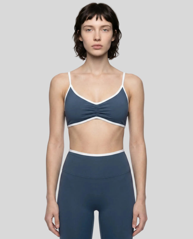 Model wearing the Athlesi TrackLine Color Block Sports Bra in blue and white front view