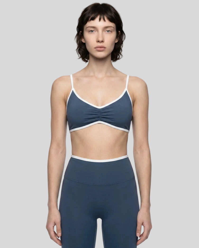 Model wearing the Athlesi TrackLine Color Block Sports Bra in blue and white front view