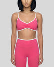 Model wearing the Athlesi TrackLine Color Block Sports Bra in pink and white front view