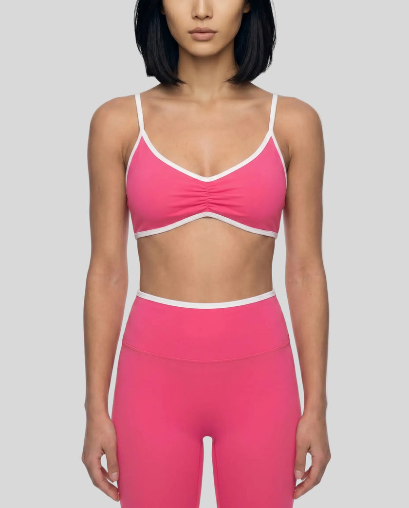 Model wearing the Athlesi TrackLine Color Block Sports Bra in pink and white front view