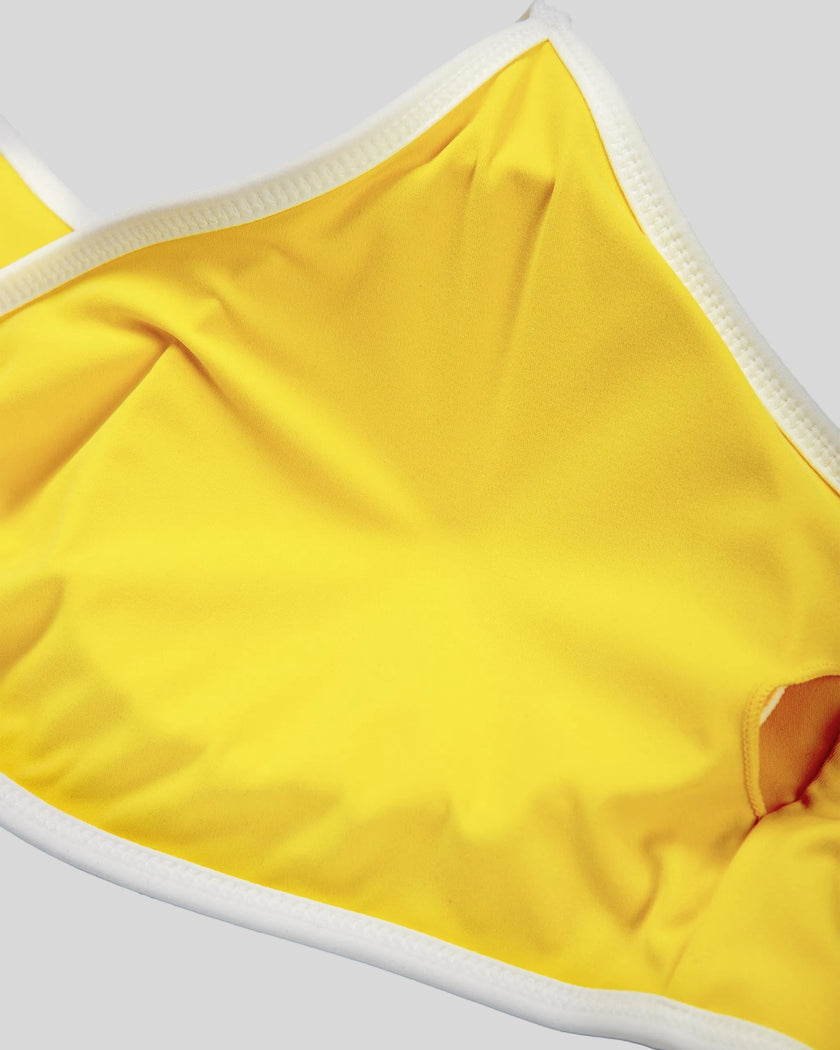 Interior fabric and support detail of the Athlesi TrackLine Color Block Sports Bra in yellow and white
