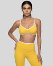 Model wearing the Athlesi TrackLine Color Block Sports Bra in yellow and white front view