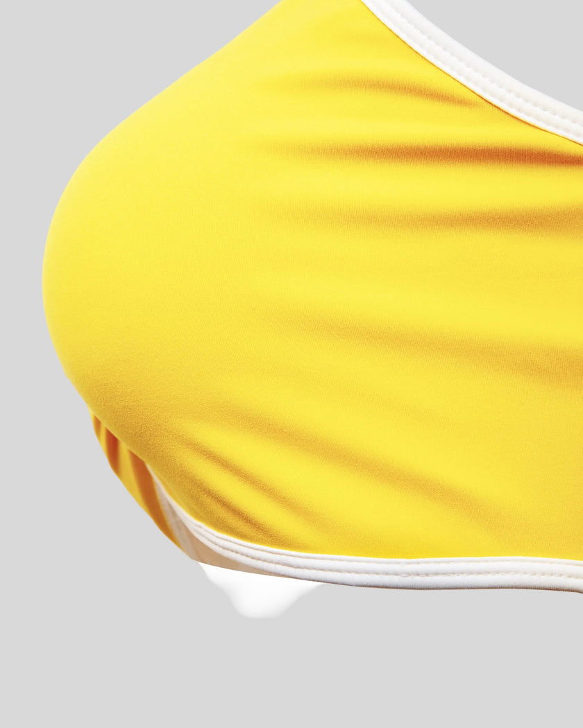 Underbust contrast trim detail of the Athlesi TrackLine Color Block Sports Bra in yellow and white
