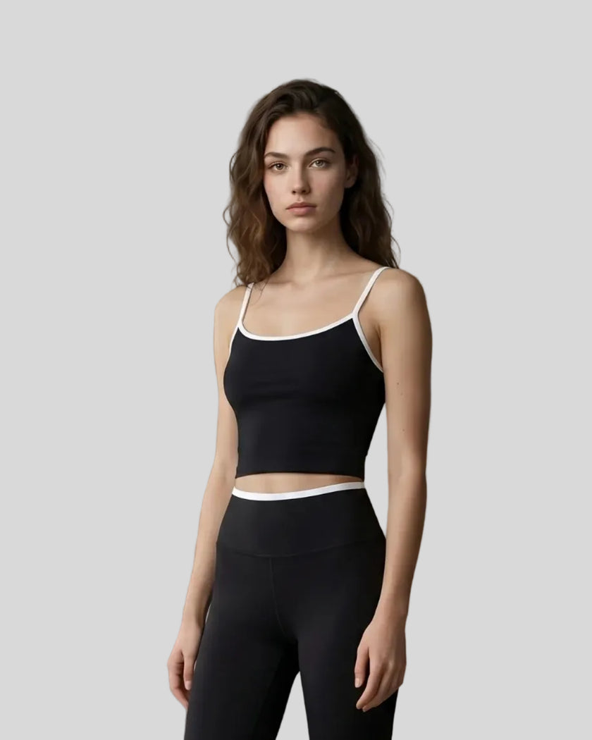 Angled front view of the TrackLine Color Block Tank in black and white, styled with Trackline Sculpt Leggings