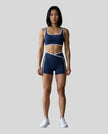 Model wearing the TrackLine Color Block Yoga Shorts in Navy Blue and White full body front view