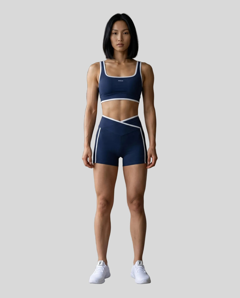 Model wearing the TrackLine Color Block Yoga Shorts in Navy Blue and White full body front view