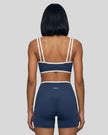 Model wearing the small-size Color Block Yoga Sports Bra in Navy Blue and White back view