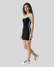 Full body left angle view of a woman wearing the Athlesi TrackLine Contour Dress in black