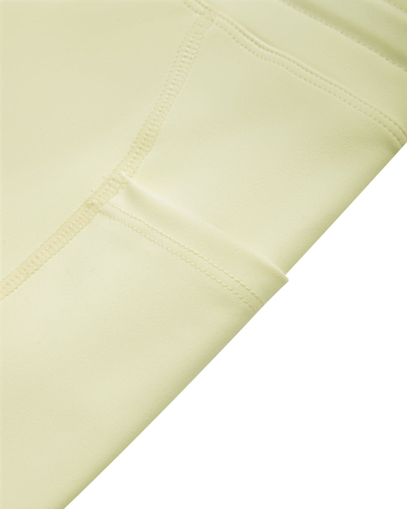 Closeup of the side pocket and contour piping on the TrackLine Contour Yoga Leggings in Light Yellow (White)
