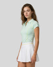 Side view of a female model wearing the TrackLine Court Polo in Mint Green.