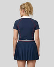 Back view of a female model wearing the TrackLine Court Polo in Navy Blue (size large)