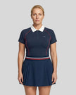 Female model wearing the TrackLine Court Polo in Navy Blue paired with Trackline Rally Skirt in Navy Blue viewed from the front.