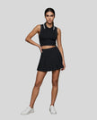 Model wearing the TrackLine Court Polo Tank in Black with White with matching TrackLine Court Skirt, viewed full body from the front angle