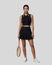 Model wearing the TrackLine Court Polo Tank in Black with White with matching TrackLine Court Skirt, viewed full body from the front.