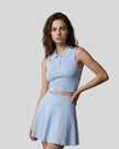 Model wearing the TrackLine Court Polo Tank in Blue with White with matching TrackLine Court Skirt, viewed full body from the front angle