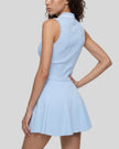Mid body side angled view of a model wearing the TrackLine Court Polo Tank Top in Blue with White