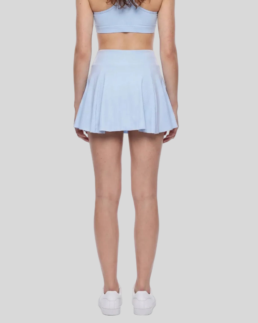 Back view of a model wearing the TrackLine Court Skirt in Blue.