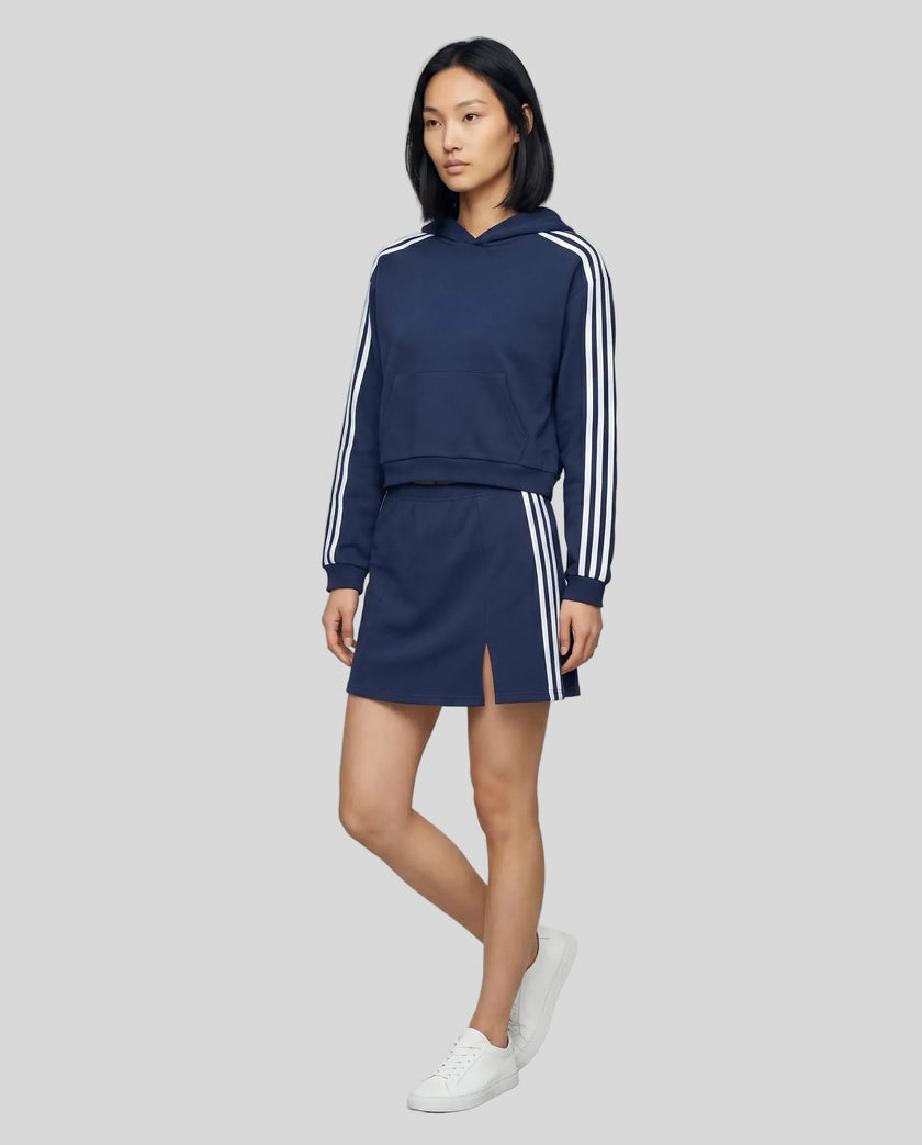 Full body front view of the Athlesi TrackLine Cropped Hoodie in blue styled with the TrackLine Slit Skirt
