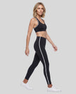 Model wearing the Athlesi TrackLine Edge Leggings in black with white side stripes from a side angle