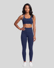 Model wearing the Athlesi TrackLine Edge Leggings in navy blue with white side stripes, front view