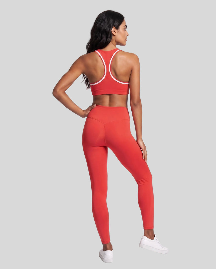 Model wearing the Athlesi TrackLine Edge Leggings in red with high-rise waist and V-shaped back seam, back view