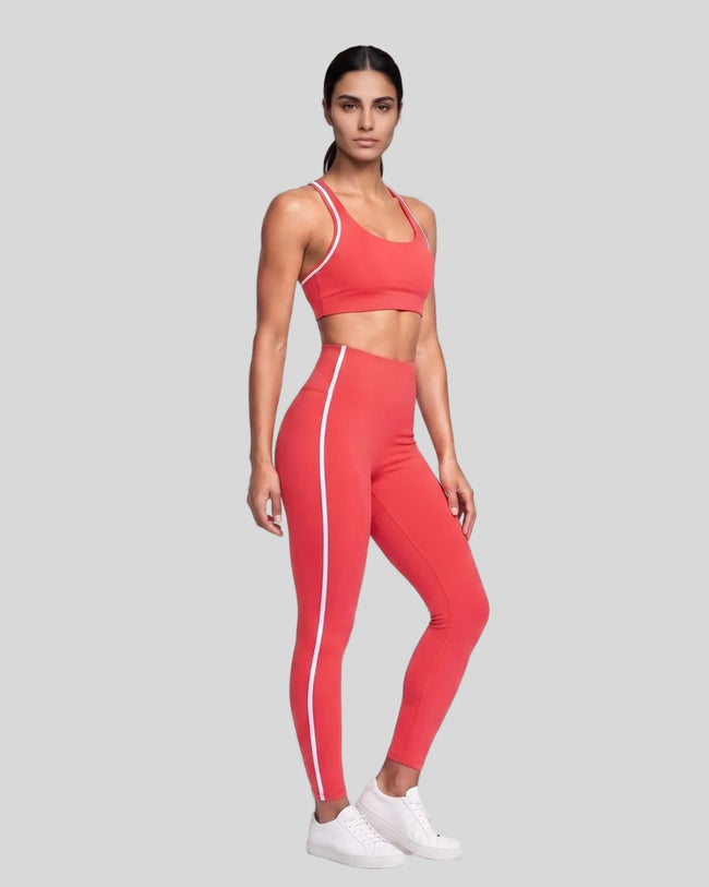 Model wearing the Athlesi TrackLine Edge Leggings in red with white side stripes from a front angle